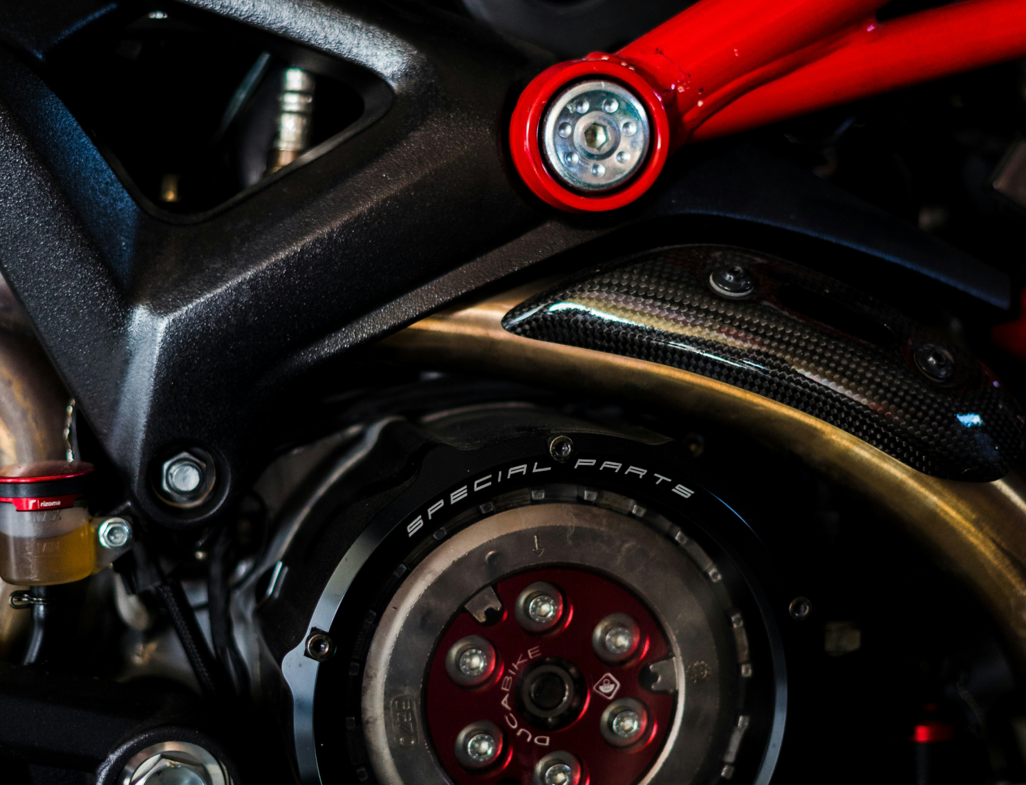 Gros plan sur des pièces mécaniques et rouges d'une moto.